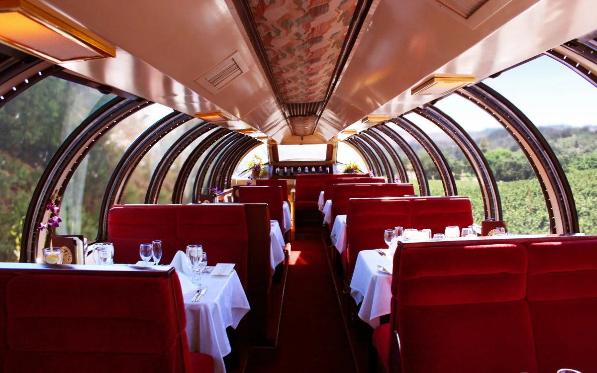 Interior de uma carruagem Vista Dome com teto de vidro no Napa Valley Wine Train, com mesas postas