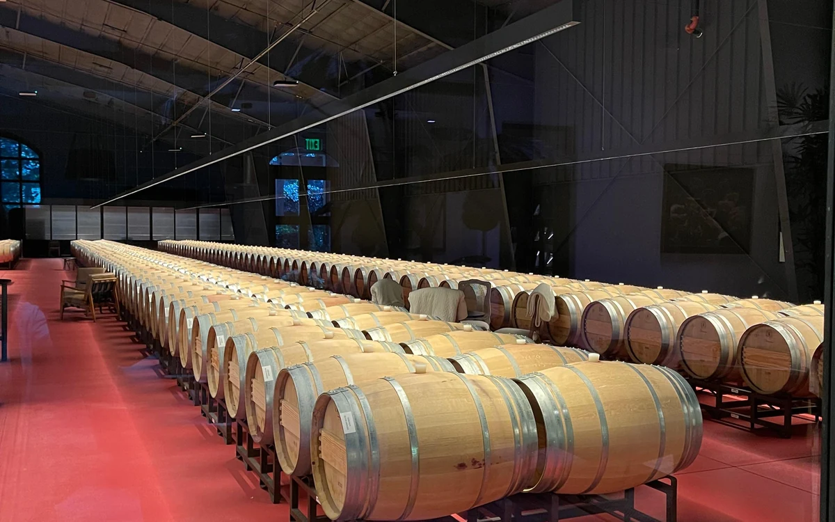 Taças servidas numa mesa de degustação numa vinícola de Napa Valley com vinhas através da janela